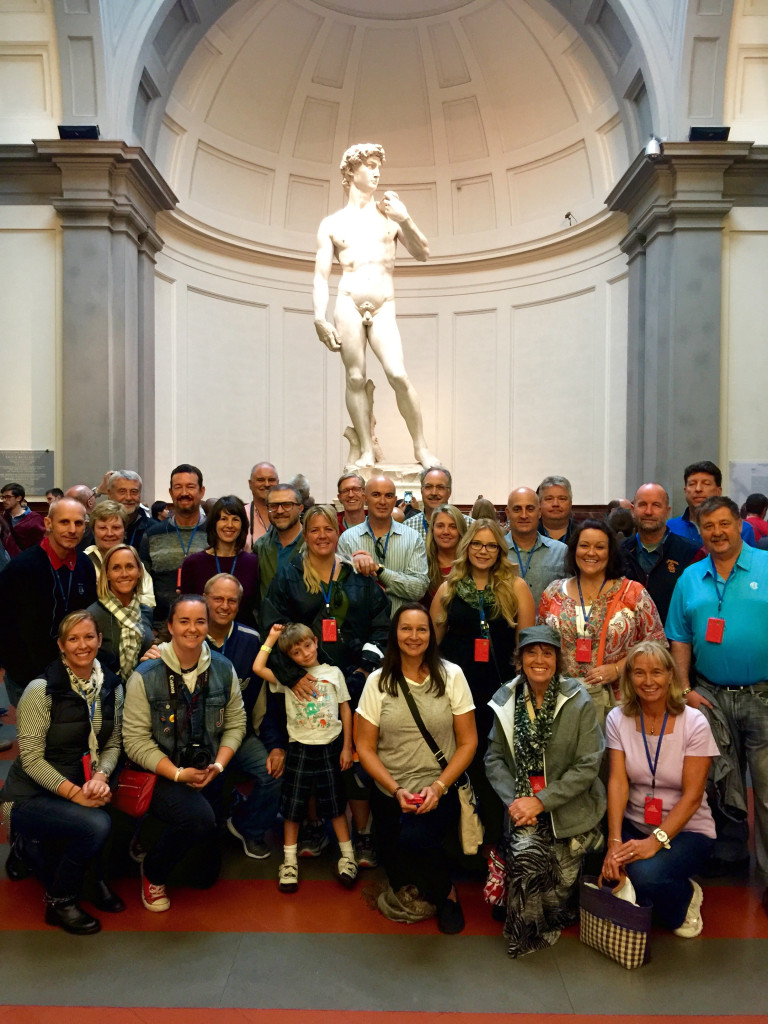 A group of people standing in front of a statue.