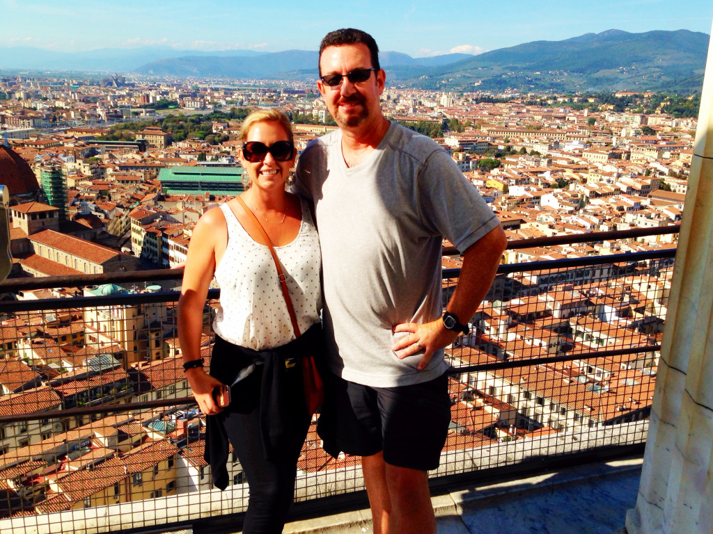 A man and woman standing on top of a building.