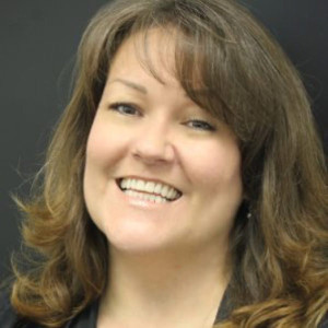 A woman with long hair smiles for the camera.